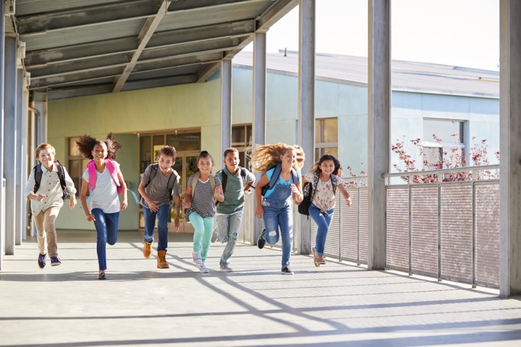 schulkinder-laufen-in-schule-hinein