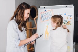 Lernentwicklungsgespräch in der Grundschule - Frau und Mädchen am Flipchart